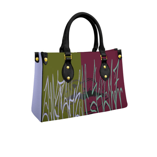 A split color block handbag with a graffiti graphic print in shades of seafoam green, lavender purple, deep maroon, and white, featuring graffiti text and an abstract torn lip background design.